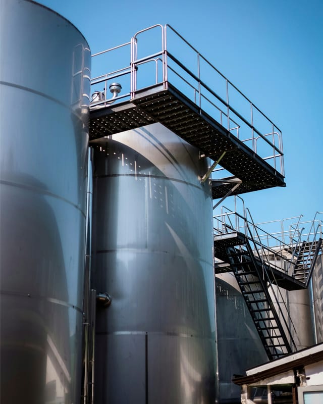 Tanques industriales con plataforma de acceso metálica en una planta de procesamiento