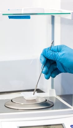 Balanza de precisión DAG en uso, pesando una muestra en laboratorio